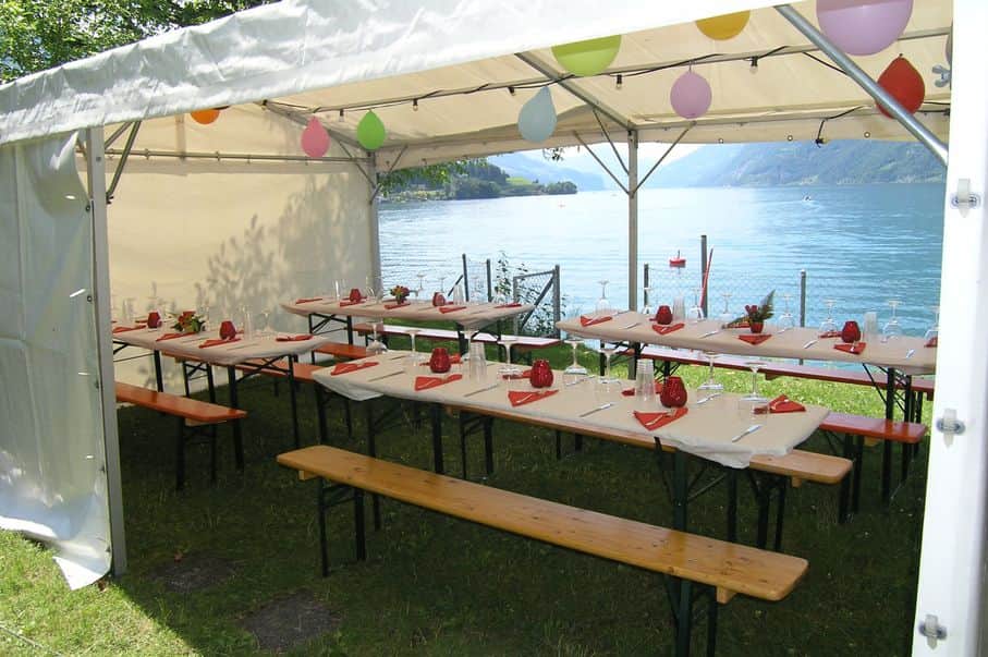 Festbänke dekoriert im Zelt auf dem Clubgelände mit Blick auf den See